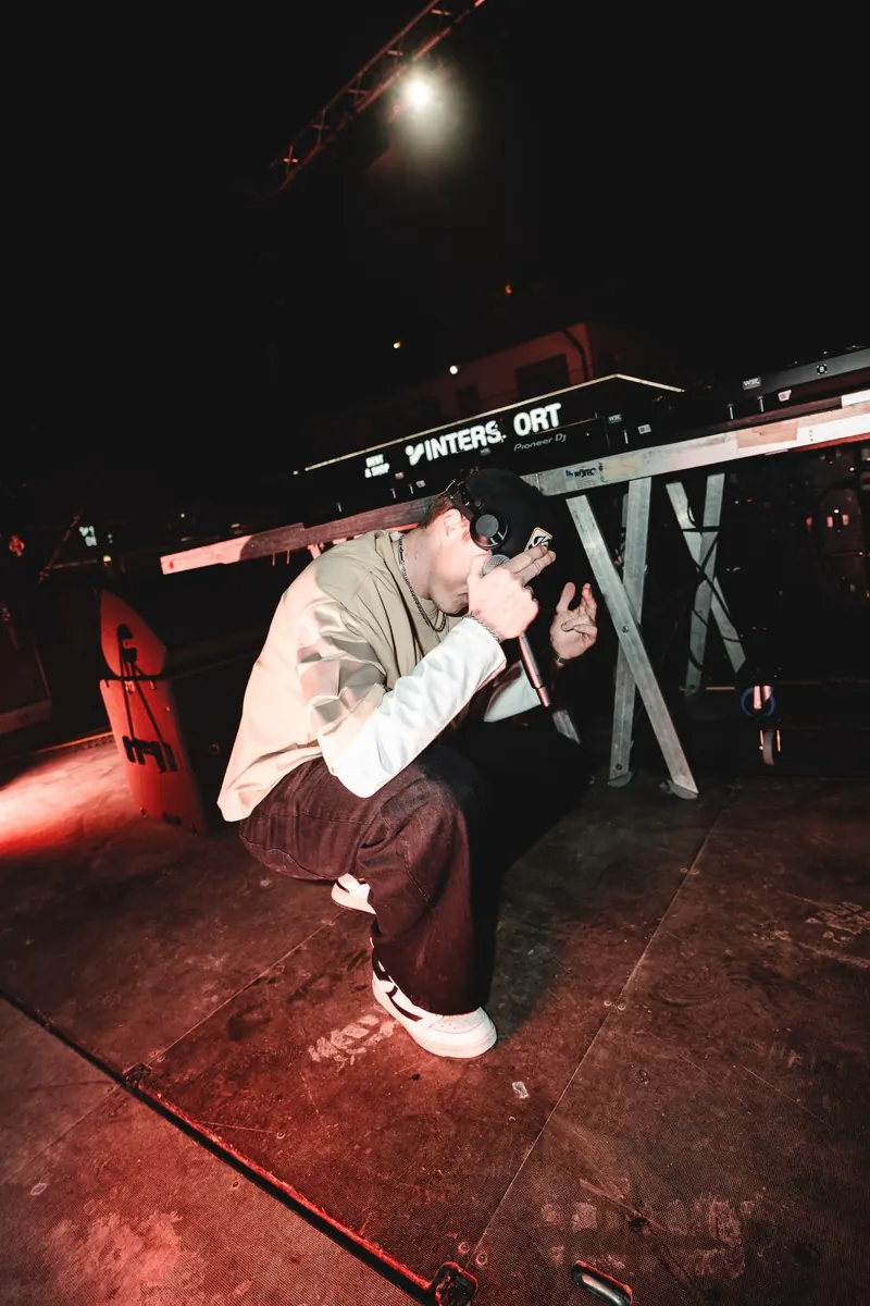 MĀT on stage in red light